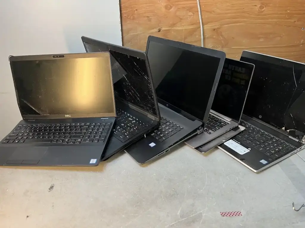 photo of 5 broken laptops lined next to each other